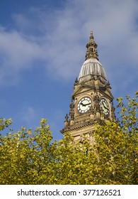 The clock tower of the town hall in Bolton, Lancashire, standing proud above the leafy tree tops in Victoria Square.