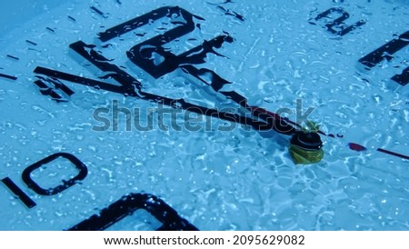 Clock under water shows the time from five to twelve background Imagine de stoc © 