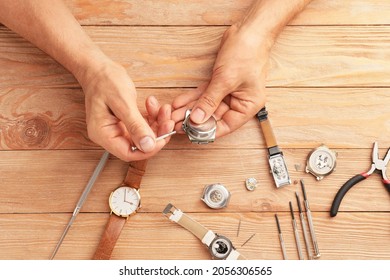 Clockmaker Repairing Broken Watch At Table