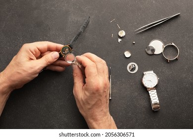 Clockmaker Repairing Broken Watch At Table