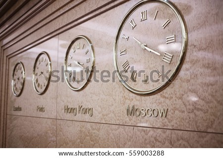 Clocks on wall showing time in London, Paris, Hong Kong and Moscow.