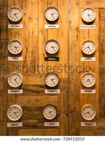 clocks on a wall with time zone of different country