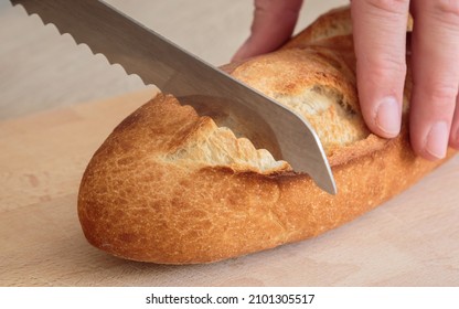 cloesup of a french baguette bread on a wooden board about to be