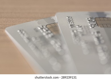 Cloesup View Of Two Silver Credit Cards On A Wooden Table