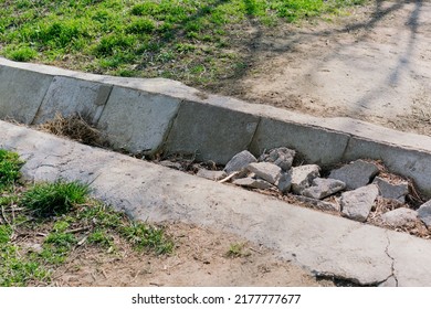 Clogged Concrete Drain With Grass In The Garden. Waste. Rocks. Dirty. Storm. Tube. Industrial. Pipeline. Industry. Equipment. Gutter. Waterway. Garden. Natural. Summer. Runoff. Control.