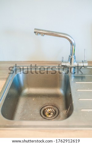Clogged kitchen sink. Dirty metal sink with leftover food. Two hole faucet