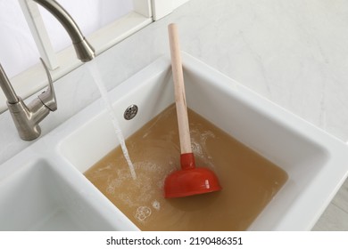 Clogged Kitchen Sink With Plunger And Dirty Water