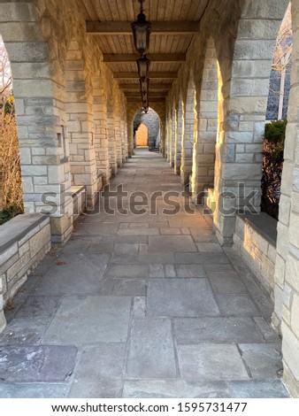 Cloistered stone archway of a suburban Chicago church at sunset during the winter solstice.