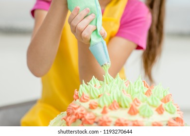 Clos Eup Little Girl Decorating Cake In The Kitchen At Home