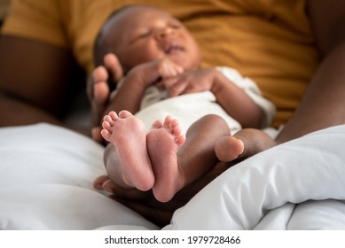 Clos Up Images Of Baby's Foot Of African Black Skin Baby Newborn, Placed On The Father's Hand, Concept To Showing Love And Concern For His Children, And Is Love Family Relationship.