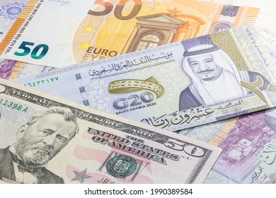 Nahaufnahme von 20 Saudi-Arabien-Riyals zwischen 50 US-Dollar und 50 Euro-Banknoten. Zwanzig Riyalbanknoten des arabischen Landes. Geld der USA und Europas mit saudischer Riyal-Banknote. Banknote des G20-Gipfels