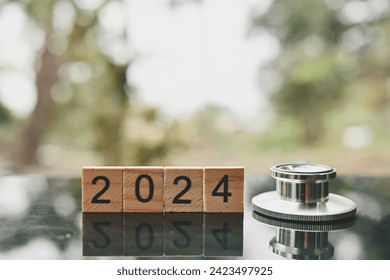 close up 2024 wooden text block and stethoscope on table, world health day, medical and healthcare, cardiology and cancer crisis risk and problem concept