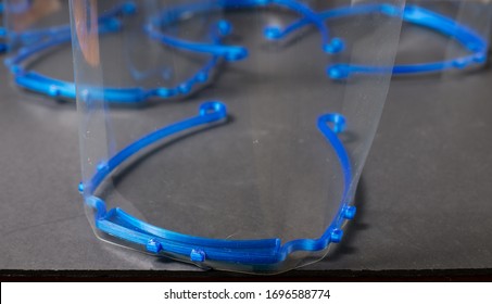 Close Up Of 3d Printed Face Shield, With More In Background.  Home Made PPE Ready For Donation To Health Care Workers During The COVID-19 Pandemic.