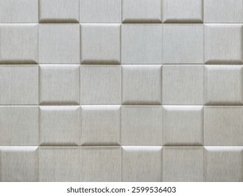 Close up of 3d wall panel in square checkerboard or checkered pattern, in bright glossy silver color. 3D beveled checkered shape used for wall sound insulation. Seamless background texture.