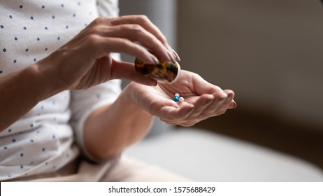 Close up 60s old woman pours out from bottle pills time to take medicaments, cure for memory loss, high blood pressure or cholesterol level remedy pain killer drugs, senile diseases treatments concept