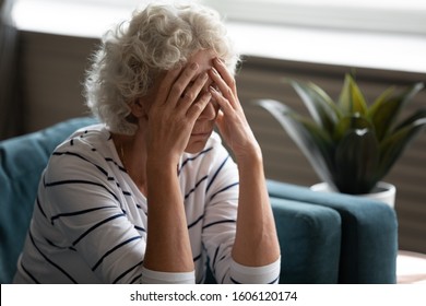 Close up 70s elderly woman sitting on sofa feels desperate crying covered face with hands, senile sickness need help, mental disorder or dementia, does not see way out difficult life situation concept - Powered by Shutterstock