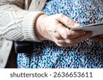 Close up of 86 yo woman wrinkled hands holding photos in Tienen, Flemish Brabant Region, Belgium 1 June 2025. Model released