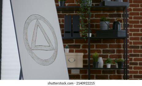 Close Up Of Aa Meeting Symbol On White Board In Room For Therapy Session. Concept Of Anonymous Alcoholics Sign In Office Decorated For Rehabilitation Program And Alcohol Addiction.