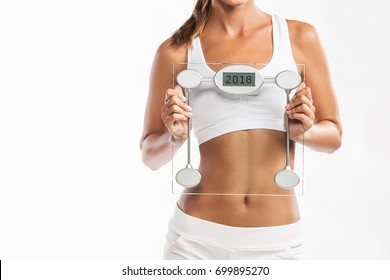 Close Up Of Woman’s Abdomen, Holding A Weight Scale With A Year 2018 Written On It - New Year’s Weigh T Loss Resolution  