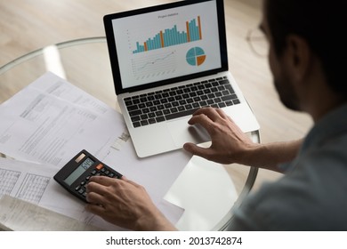 Close up above view man sit at table verifies data, financial report with graphs and charts infographic seen on computer monitor. Calculate finances, prepare research using computer program software - Powered by Shutterstock - Get 15% off with code: PIKWIZARD15
