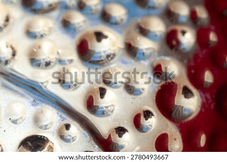 Close up abstract metallic surface with rounded reflective dimples and warm gold tones. Glossy futuristic texture background with reflective highlights and organic pattern detail.