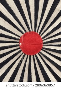 close up of an abstract radial pattern in black and white with a striking red center that resembles the shape of a shining sun