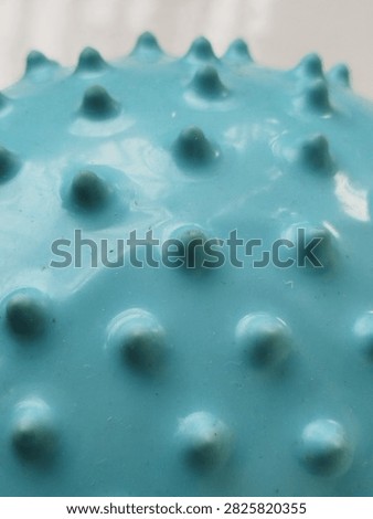 Close up abstract texture of a blue rubber sensory spike ball surface