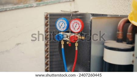 Close up of ac gauges vacuum pump used for checking air conditioner freon in need of maintenance. Set of refrigerant levels pressure measurement device mounted on HVAC system