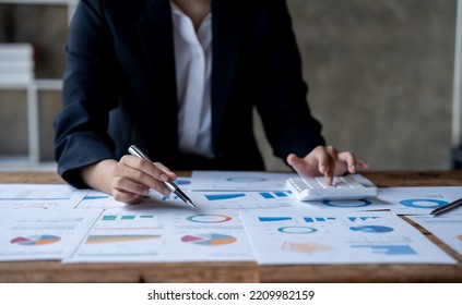 Close up accounatant using calculator, managing household monthly budget, summarizing taxes or bills, planning future investments, doing financial affairs at home, accounting bookkeeping concept - Shutterstock ID 2209982159