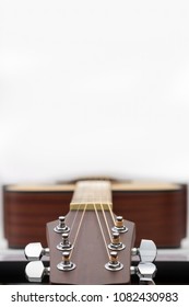 Close up of an acoustic guitar headstock on white background with copy space.