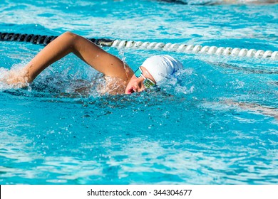 Close up action shot of Teen boy swimming freestyle at swimming lesson.