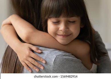 Close up of adorable brown-haired cutie little daughter face with closed eyes cuddle her mother showing sincere love and strong attachment heartfelt moment, new mom for adopted grateful child concept - Shutterstock ID 1569482914