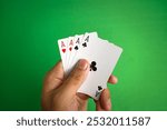 close up of adult hand holding four aces poker cards on green table for background