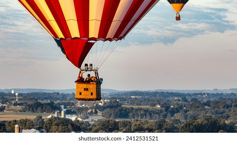 An Close Aerial View of Hot Air Balloons Floating Away in Rural Pennsylvania at Sunrise on a Sunny Summer Morning - Powered by Shutterstock