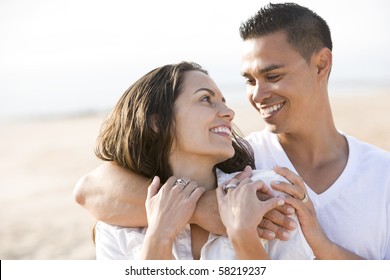 Close Up Of Affectionate Hispanic Couple On Beach Looking At Each Other