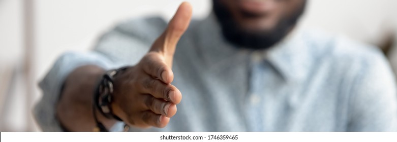 Close Up African Agent Reach Out Hand To Camera Handshake Client. Make Deal, Company Boss HR Recruiter Greet Applicant Starting Job Interview Concept. Horizontal Photo Banner For Website Header Design