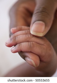 close up of an african american baby hand in mother's hand