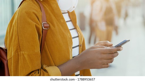 Close Up Of African American Female Hand Holding Smartphone Device And Tapping On Screen. Outdoor. Woman Tourist Scrolling And Typing On Mobile Phone At Street On Bus Stop.