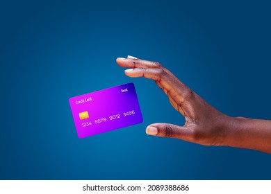 Close up african american female hand and levitating mockup bank credit card with online service on blue background