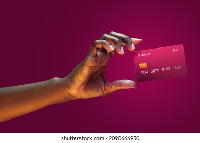 Close up african american female hand hold levitating mockup Bank credit card with online service on magenta background - Shutterstock ID 2090666950
