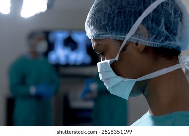 Close up of african american female surgeon wearing face mask in operating theatre at hospital. Hospital, surgery, hygiene, medicine, healthcare and work, unaltered. - Powered by Shutterstock