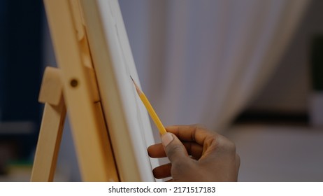 Close Up Of African American Hand Of Artist Holding Pencil For Authentic Vase Drawing On White Canvas Sitting At Home. Black Young Adult With Artistic Imagination Creating Professional Design