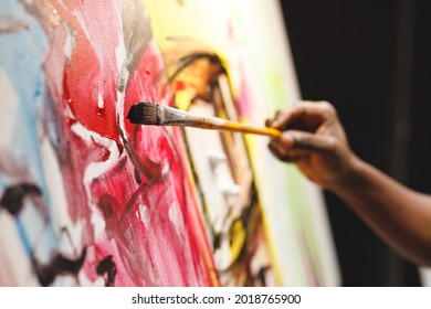 Close up of african american male painter at work painting on canvas in art studio. creation and inspiration at an artists painting studio.