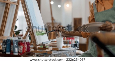 Close up of african american male painter at work painting on canvas in art studio. creation and inspiration at an artists painting studio