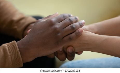 Close up african american man hands holding upset depressed woman, comforting wife for supporting frustrated disappointed girlfriend having life problem, showing love and support. - Powered by Shutterstock