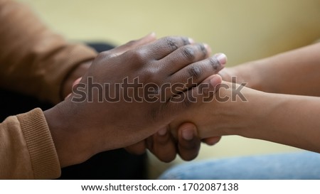 Close up african american man hands holding upset depressed woman, comforting wife for supporting frustrated disappointed girlfriend having life problem, showing love and support.