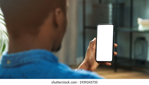 Close Up Of African American Man Holding New Black Smartphone With Blank Screen In Hands. Mobile Phone With Blank Copy Space Screen For Your Text