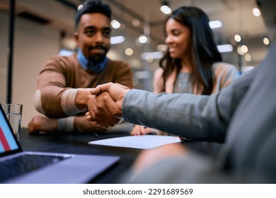 Close up of African American man shaking hands with his financial advisor.  - Powered by Shutterstock