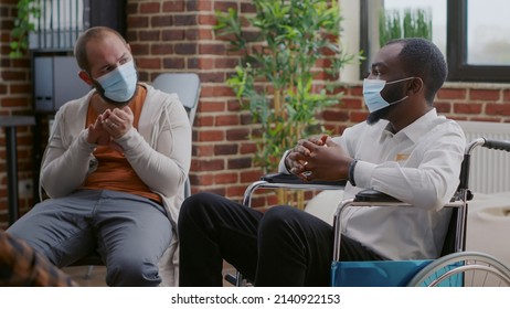 Close Up Of African American Man Sitting In Wheelchair At Aa Group Meeting, Wearing Face Mask. Adult With Disability Attending Therapy Session With People During Covid 19 Pandemic.