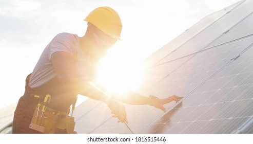 Close up of African American mechanic in protective helmet repairs solar panel with screwdriver. Technical review of modern technologies. - Powered by Shutterstock